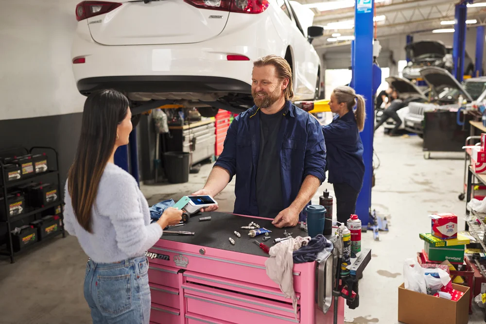 Car repair merchant accepting customer's contactless payment