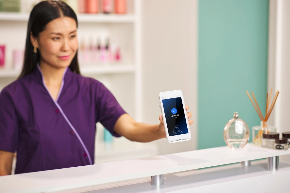 Beauty salon merchant holding out Smartpay A920Pro purchase ready