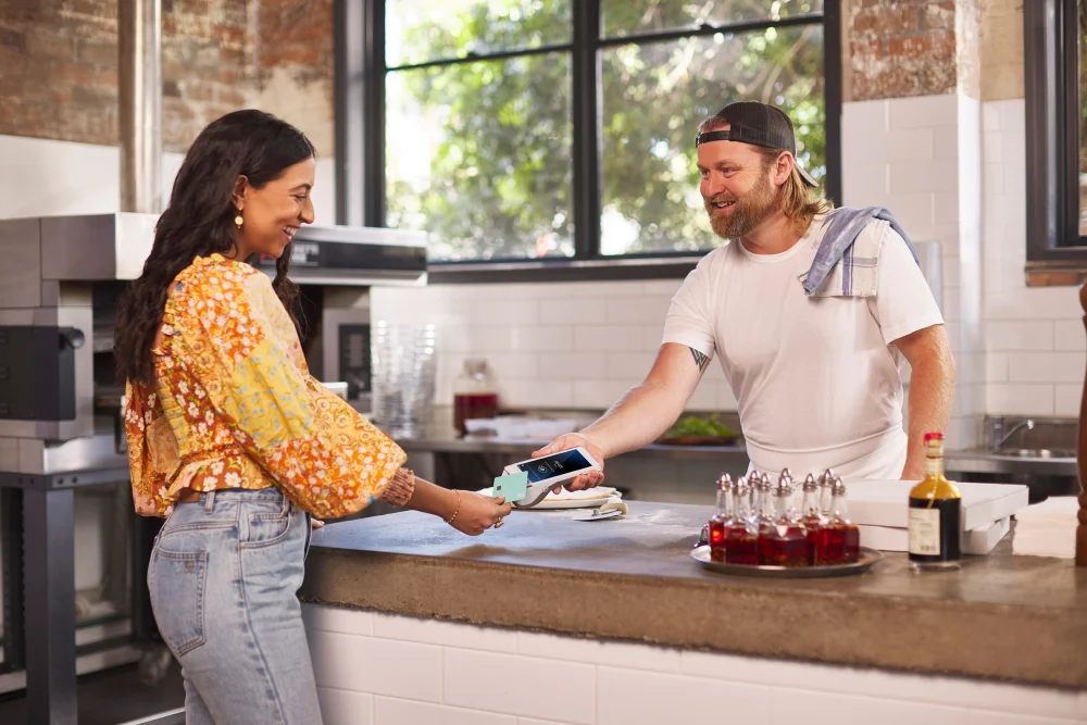 Woman paying for food in pizza restaurant